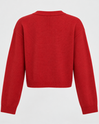Close view of fine-gauge knit cardigan showing button placket and ribbed cuff