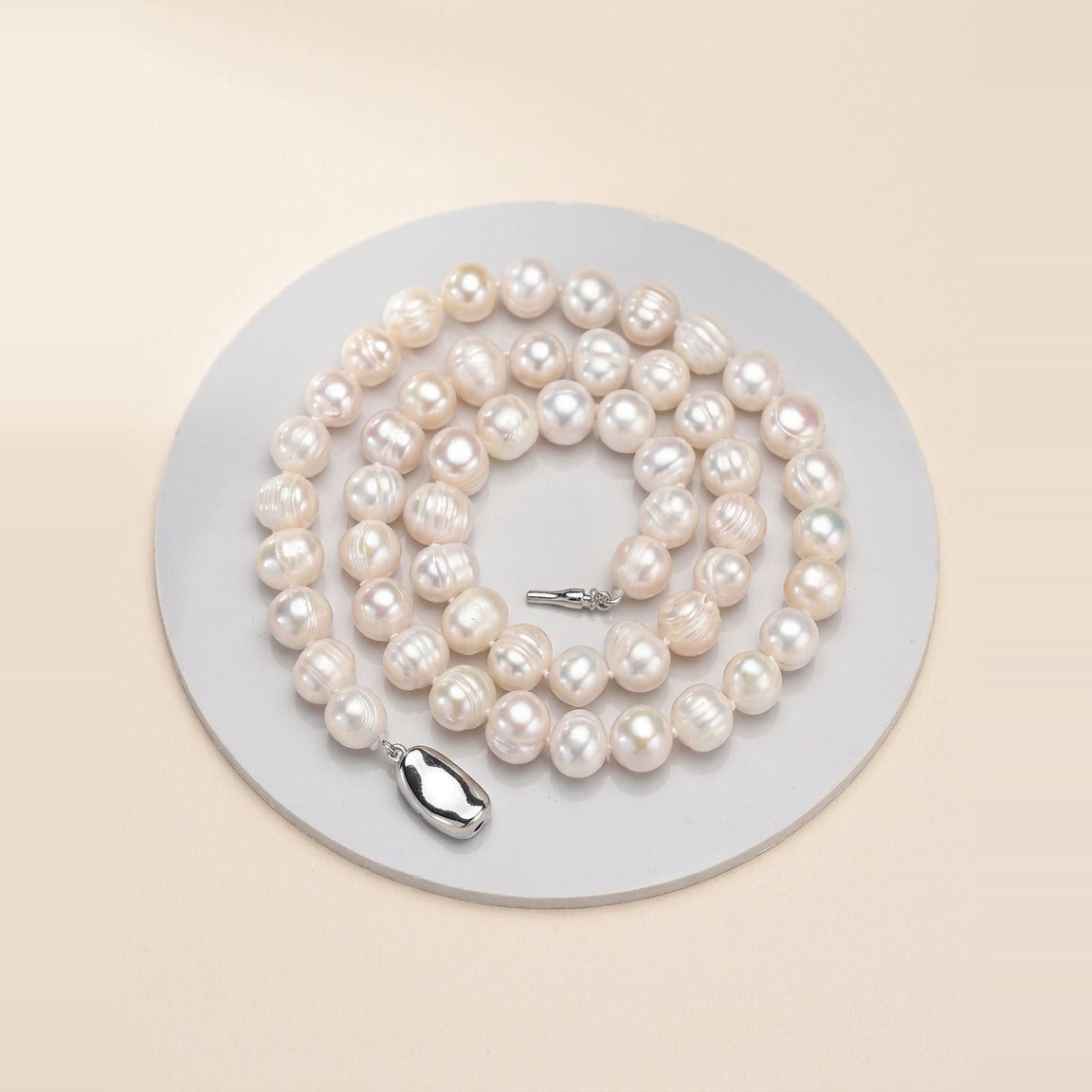 Baroque Pearl Strand Necklace in Pearl, laid flat on a surface.