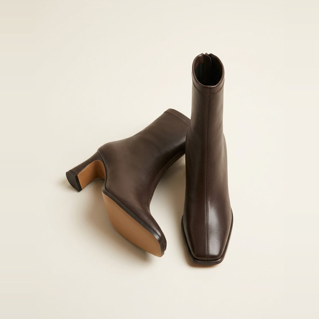 Pair of square-toe ankle boots in chocolate on crinkled paper