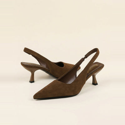 Pair of chocolate faux suede slingback pumps with pointed toes resting on a box