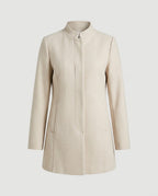 Cream collarless coat with three-button front, worn open