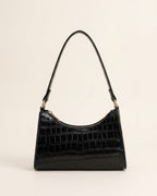 Croc-embossed baguette shoulder bag in black against a neutral background.