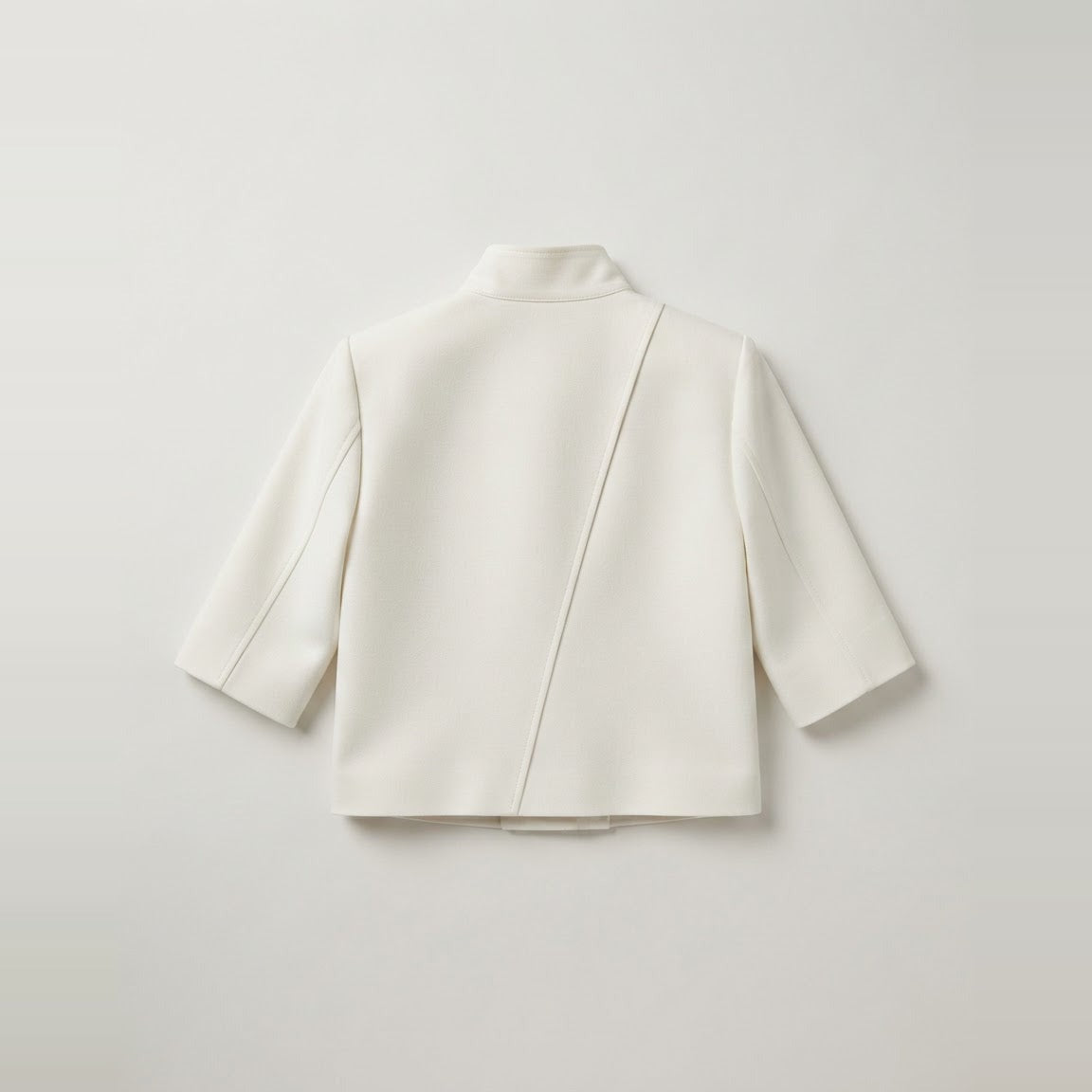 Cropped ivory jacket showing structured shoulder and three-quarter sleeve