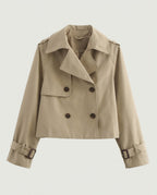 Front view of cropped trench jacket in camel with double-breasted buttons and buckled cuffs.