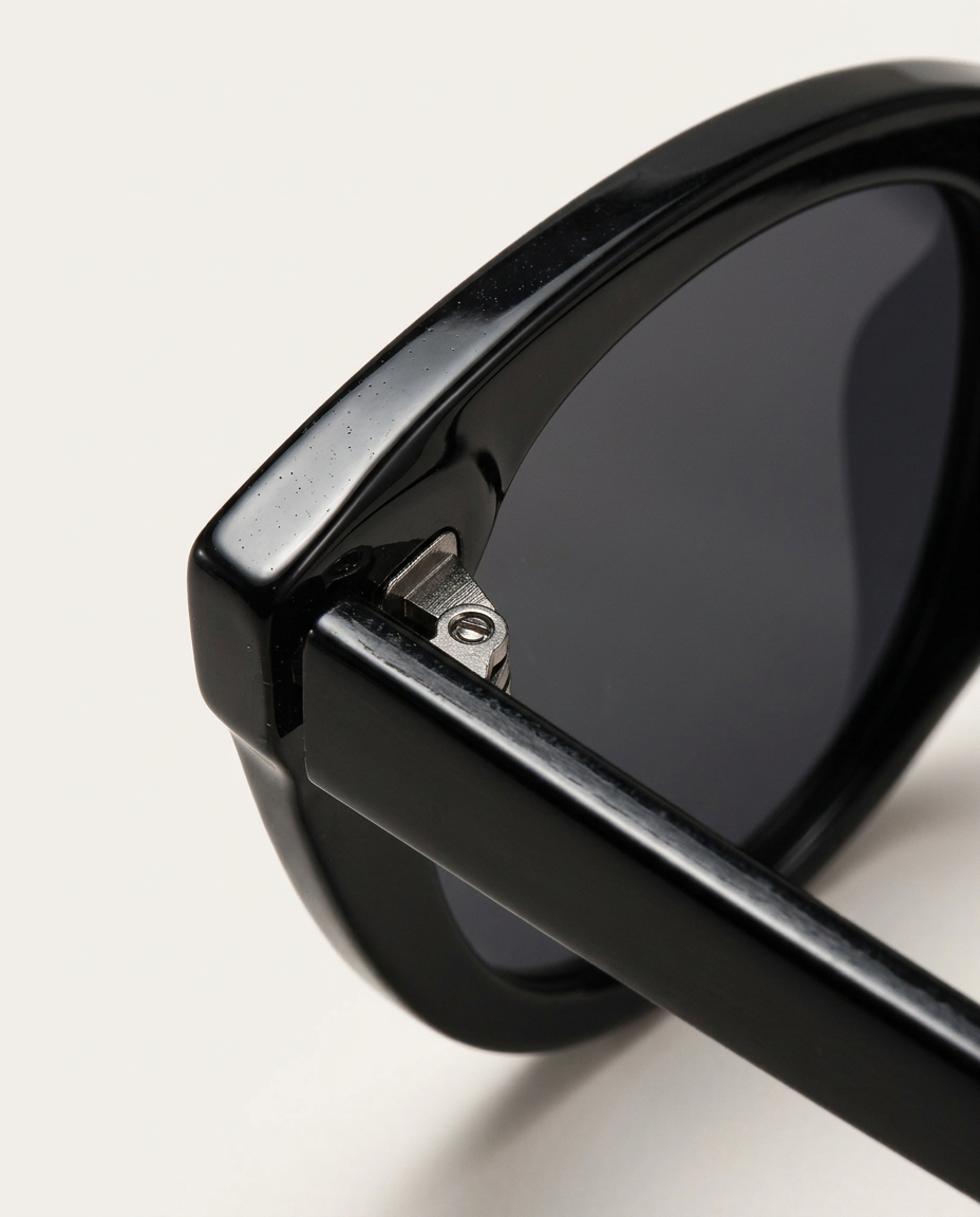 Close-up of the temple and rim of cat-eye sunglasses in black.
