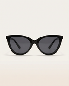 Cat-eye sunglasses in black on an angled plinth.
