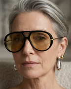 Side view of woman wearing oversized pilot sunglasses in black