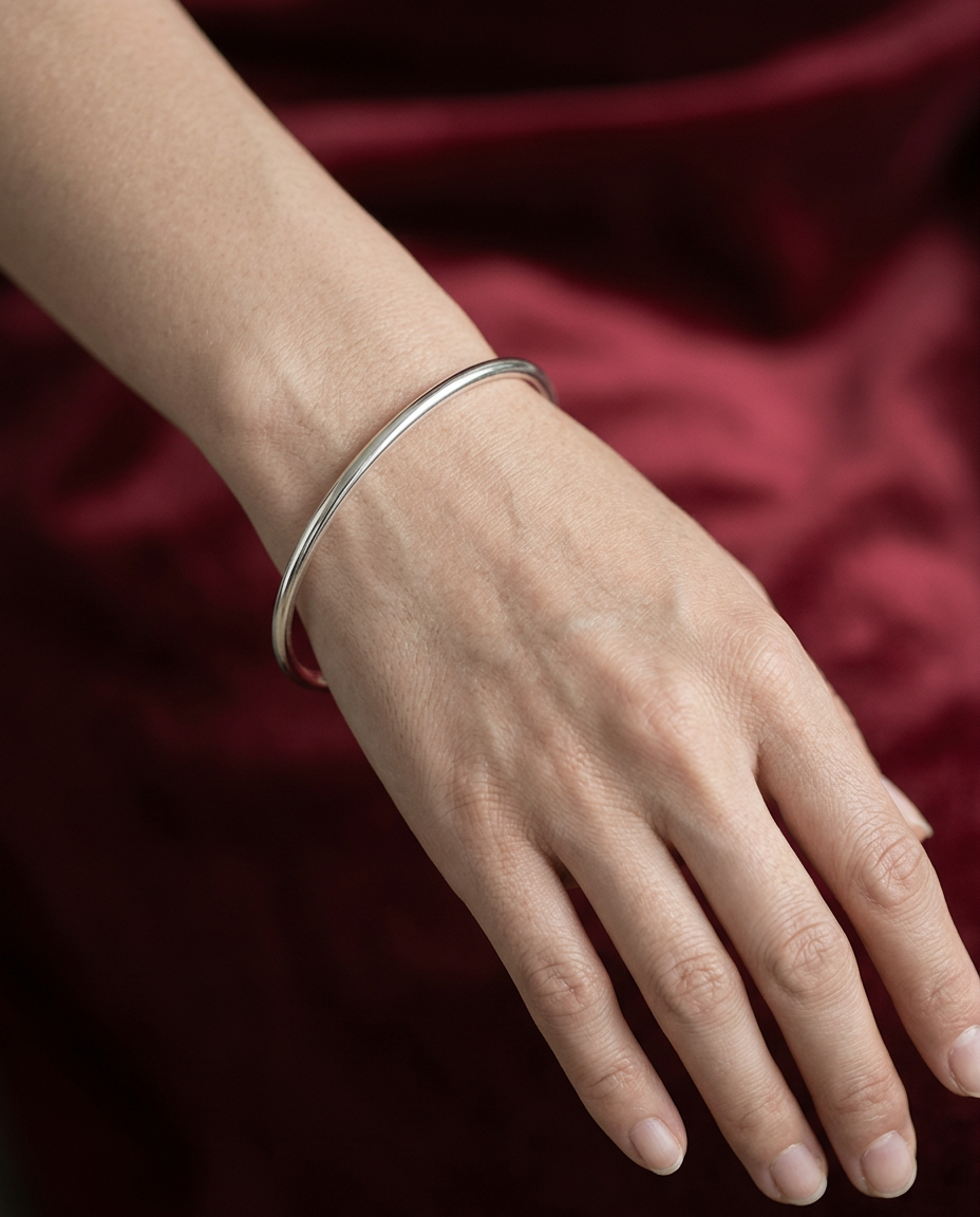 Simple metal bangle worn on the wrist in Silver.
