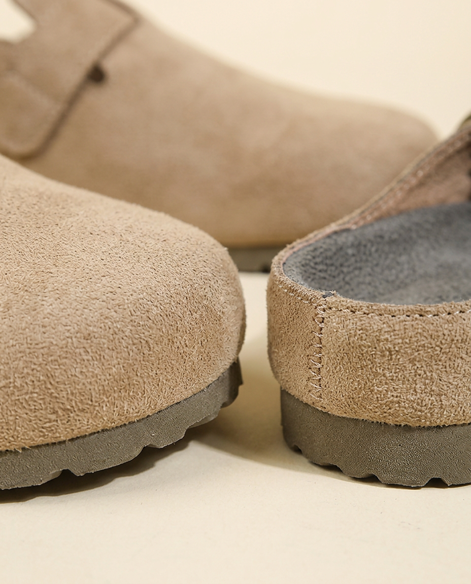 Macro view of the faux suede material and metal buckle on the Taupe mule.