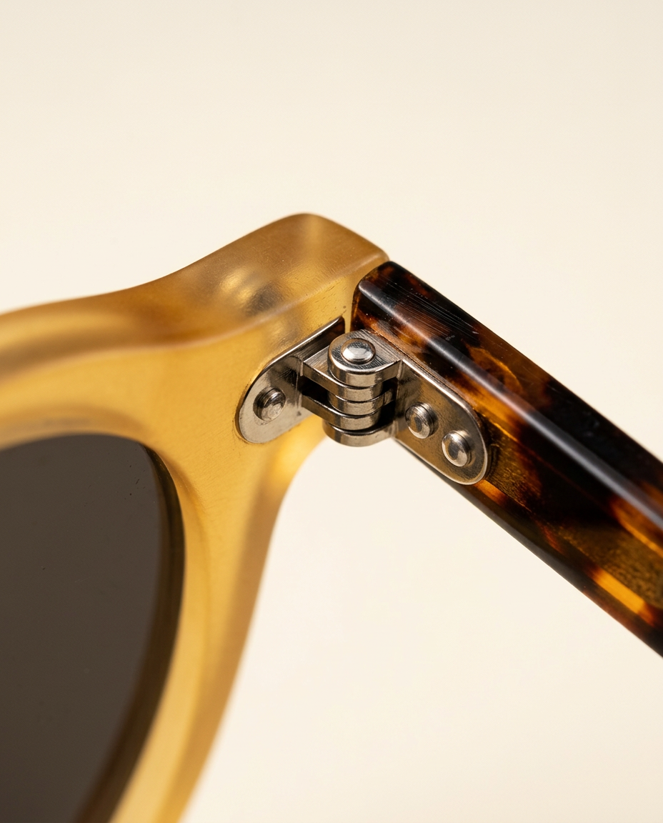Close-up of the dual pin hinges on sunglasses in camel and chocolate.