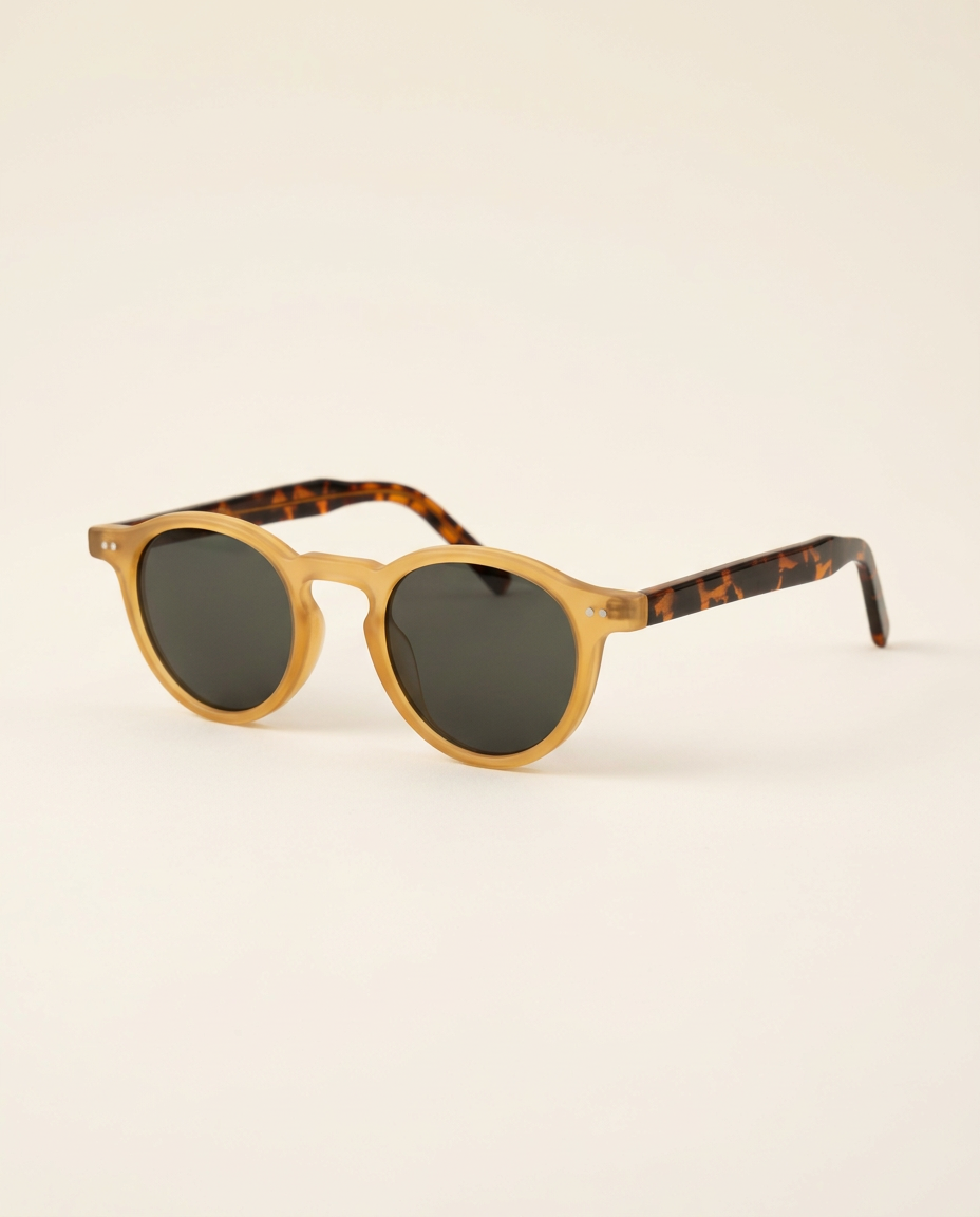 Matte keyhole round sunglasses in camel and chocolate displayed on a dark surface.