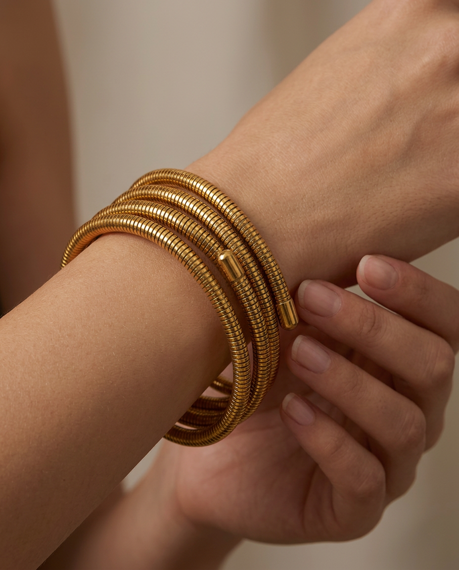 Gold coil bracelet wrapped multiple times around the wrist