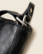 Close-up of the smooth grain texture and zip pouch in black