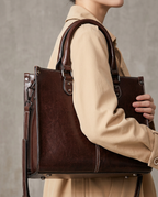 Structured tote in chocolate worn on the arm against a trench coat