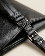 Close-up of the crinkled texture and edge seam on the envelope clutch in black