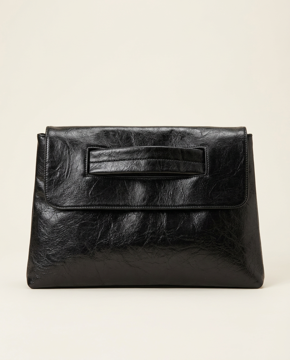 Textured oversized envelope clutch in black held under the arm