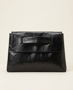 Textured oversized envelope clutch in black held under the arm