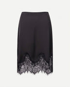 Black satin skirt showing the lace trim at the hem