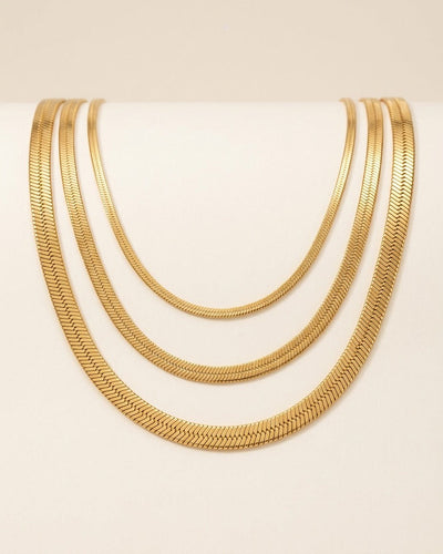 Layered herringbone necklace set worn close to the collarbone in Gold.