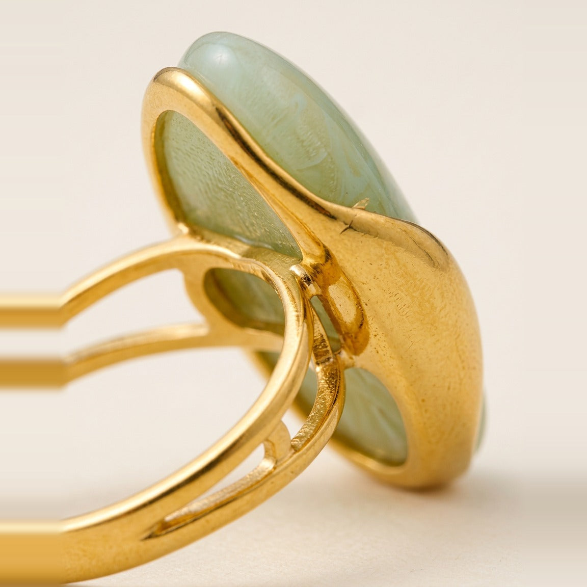 Polished gold-tone setting holding the Cognac marbled stone.