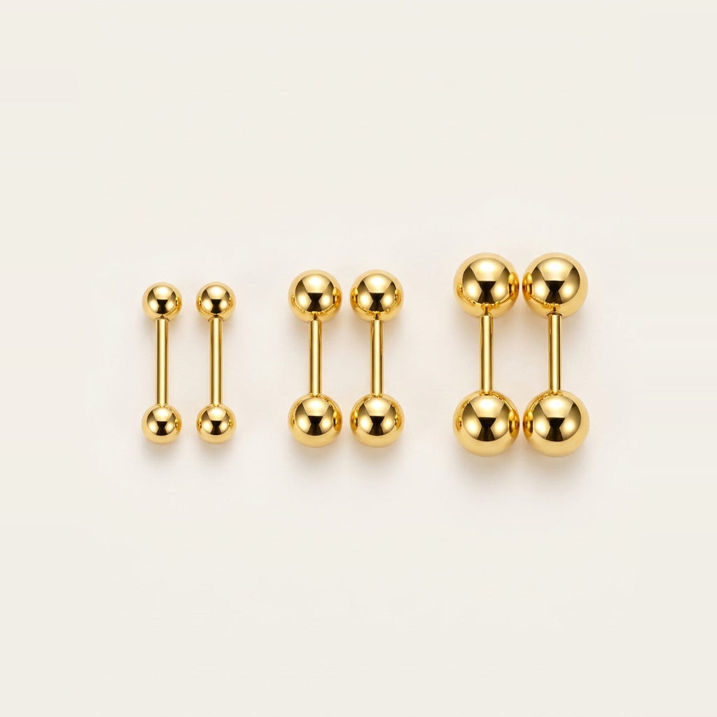 Mini Ball Stud Earrings in Gold, worn on the earlobe.