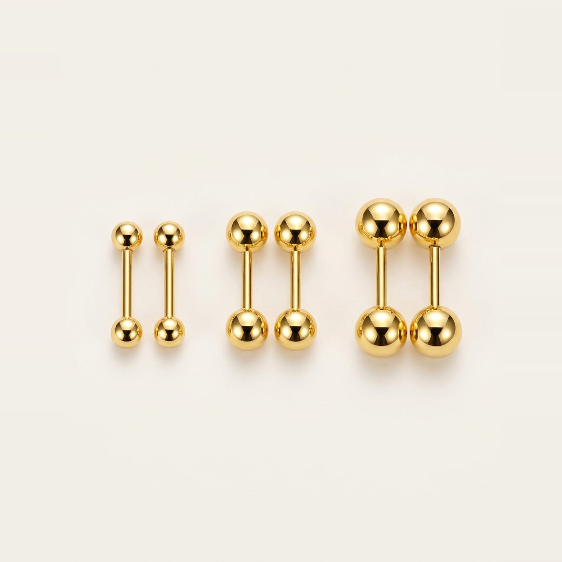 Mini Ball Stud Earrings in Gold, worn on the earlobe.