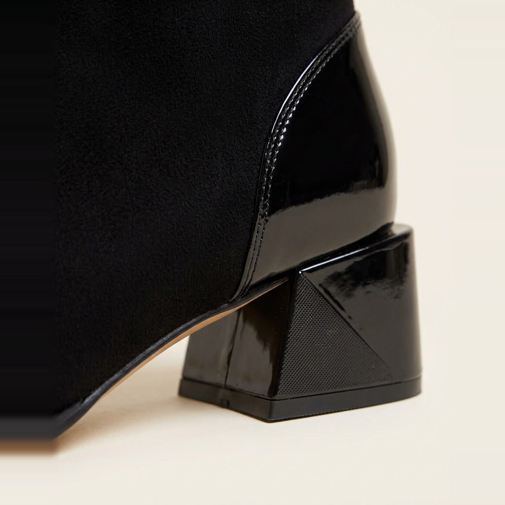 Detail of the glossy patent toe cap and textured block heel in Black.