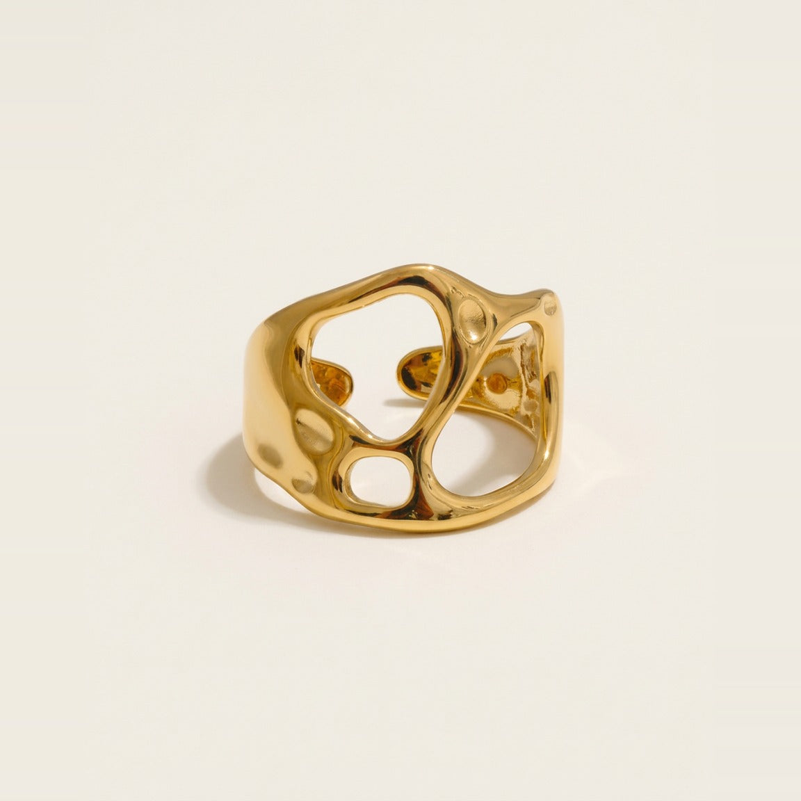 Hero view of the sculptural molten cutout ring in gold.