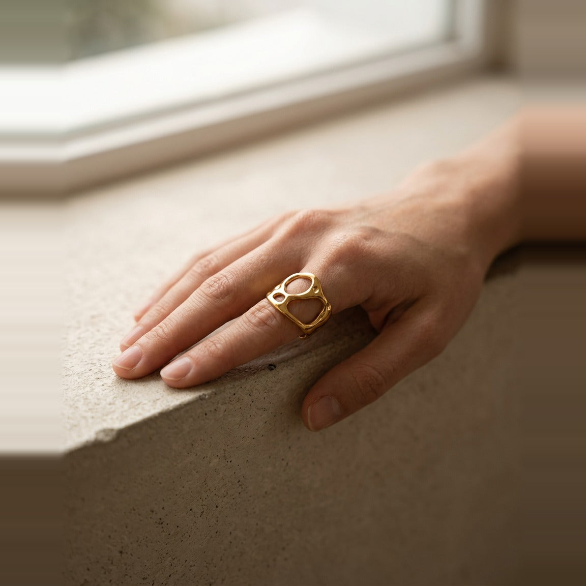 Worn view of the wide cutout band ring in gold.