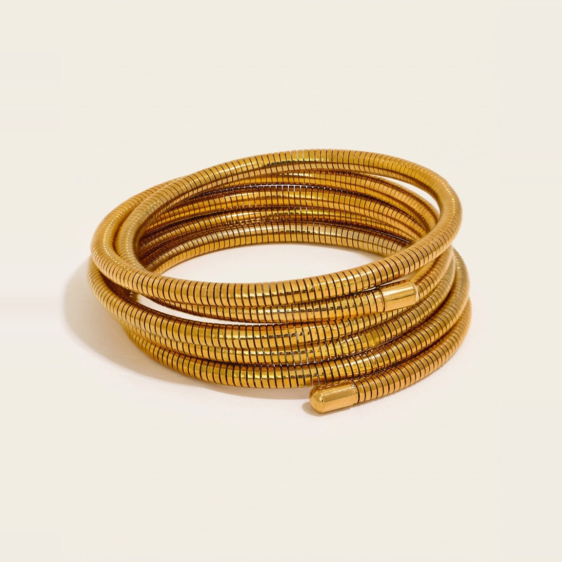 Gold Serpentine Coil Wrap Bracelet coiled tightly on a white background