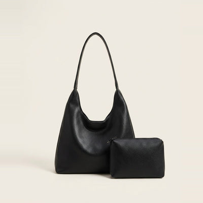 Slouchy hobo shoulder bag and matching pouch in black resting by a window