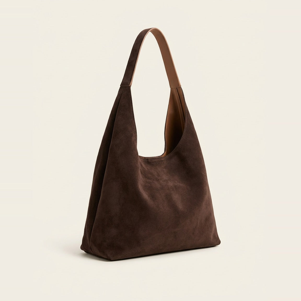 Slouchy shoulder bag in Chocolate worn over a black coat.