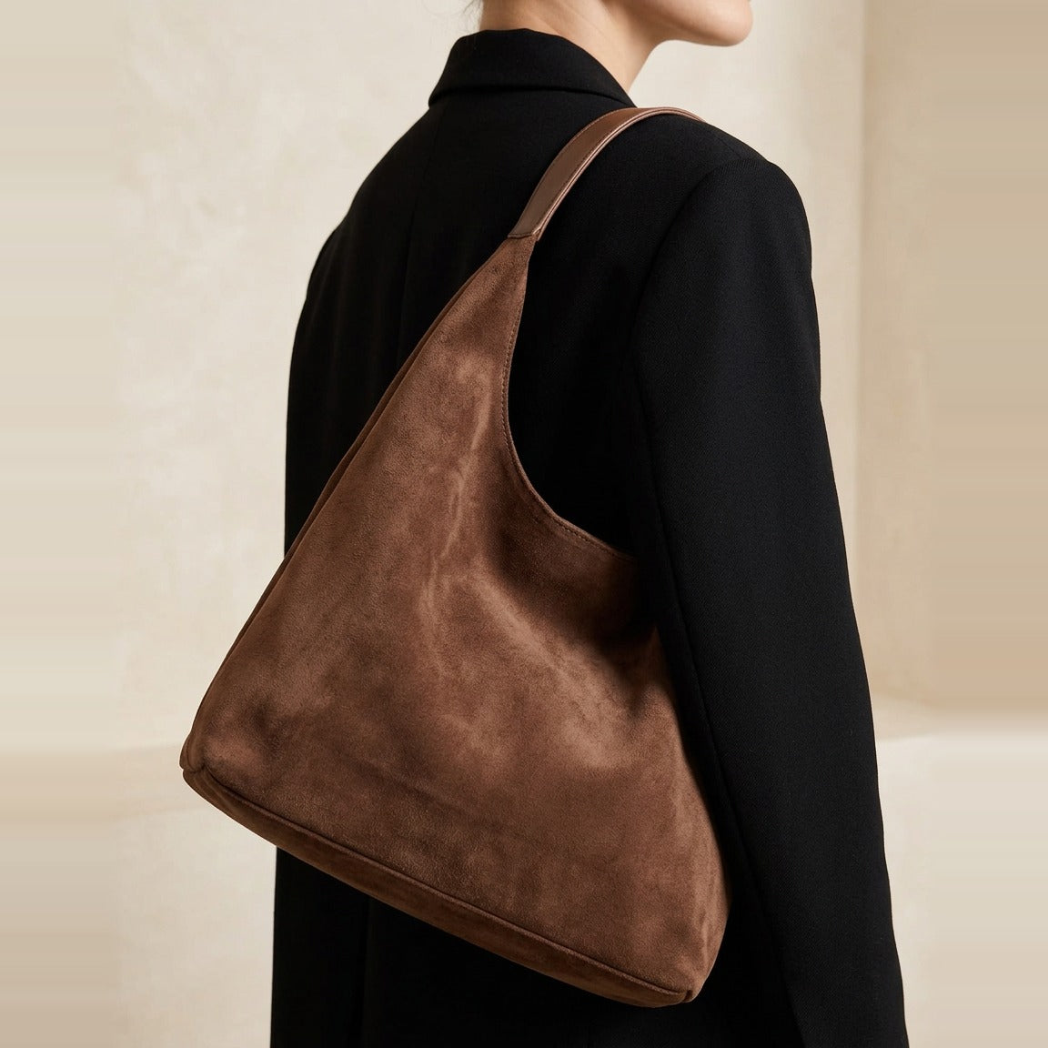 Detail of the wide shoulder strap and gathered opening of the bag in Chocolate.