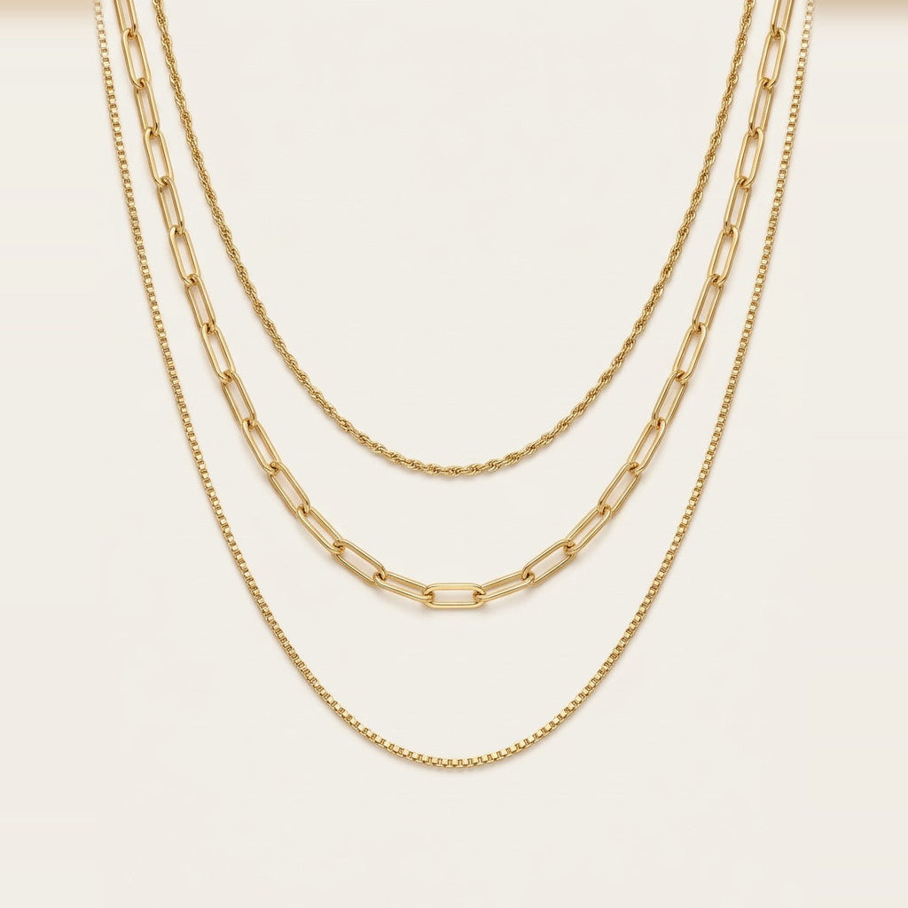 Triple Chain Necklace in Gold, worn layered at the neckline.