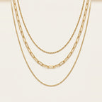 Triple Chain Necklace in Gold, worn layered at the neckline.