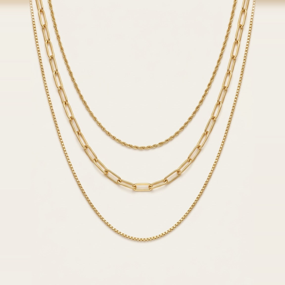 Triple Chain Necklace in Gold, worn layered at the neckline.