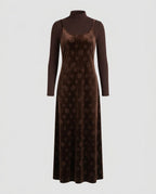 Black velvet midi slip dress with thin straps worn over a long-sleeve top.